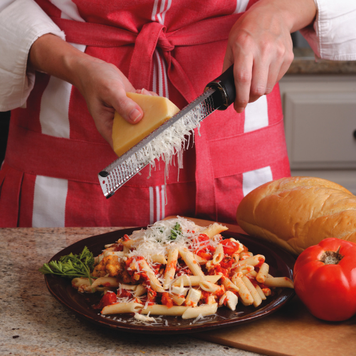 Microplane Premium Classic Zester grating cheese over pasta dish